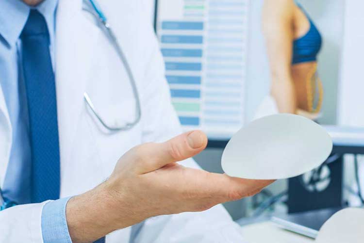 Doctor holding breast implant (model)